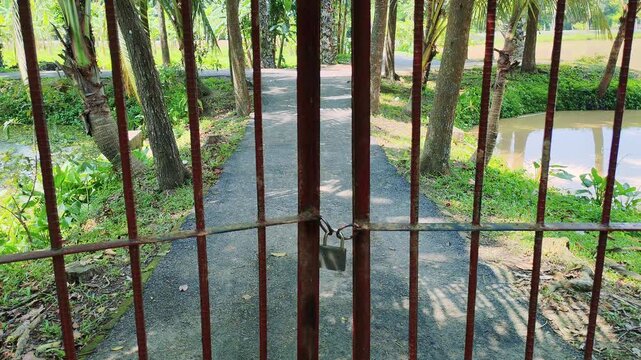 Locked Gate Framing Nature Path Symbolizing Life Barriers Social Restrictions and Emotional Isolation with a Journey Beyond Constraints Conceptual Landscape Scene