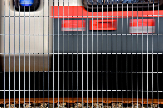 Metal grating abstract with commuter train passing in background 