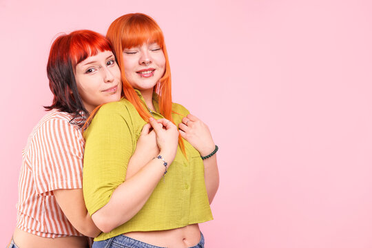 Lovely lesbian couple on pink background, space for text. LGBT concept