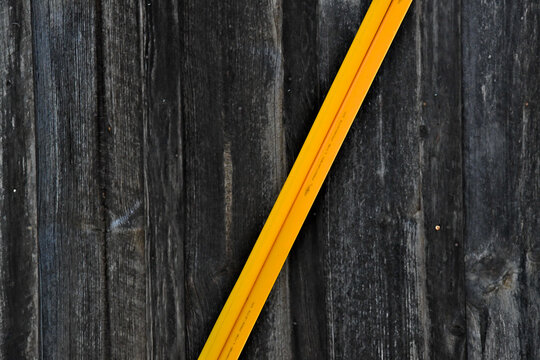 New Diagonal yellow plastic guard and old vertical weathered wooden slats. Diagonal lines create movement or tension, whereas vertical lines often convey stability and strength 