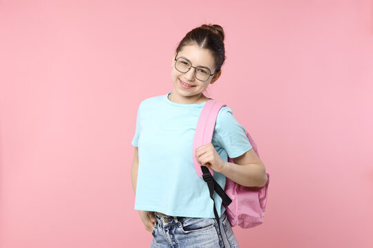 Teenage girl with backpack on pink background