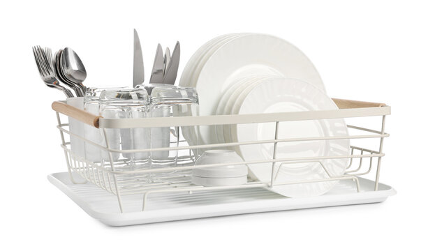 Clean dishes, glasses and cutlery in drying rack on white background