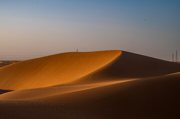 Minimal desert landscape featuring smooth sand dunes and soft natural light. Clean and calm composition with large copy space, ideal for backgrounds, travel concepts, nature themes, © Tugrul