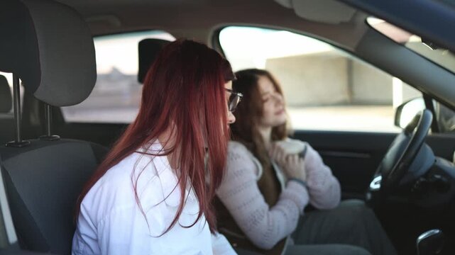 Instructor turns toward student inside car explaining next step calm supportive interaction while beginner listens with slight anxiety preparing mentally before continuing driving lesson