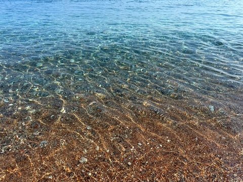Crystal clear sea water with small pebbles and sand.