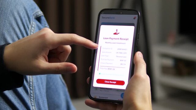 Close-up of digital payment processing on a smartphone. User reviews a successful loan repayment receipt in a stylish fintech interface. Essential footage for banking services, mobile app promos, and