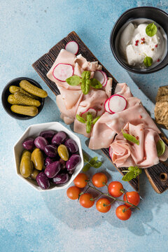 Slices Of Traditional Italian antipasti mortadella Bolognese on a wooden cutting board.
