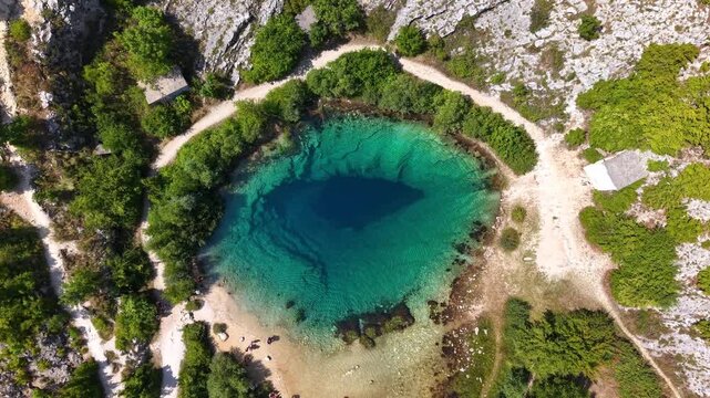 Aerial top-down view of the Eye of the Earth, Cetina River Spring in Croatia, turquoise karst spring water footage