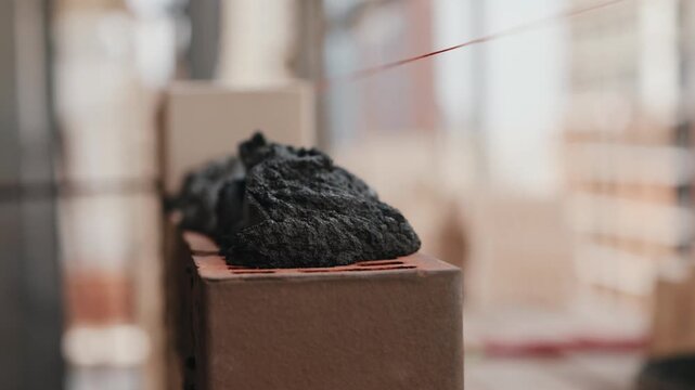 Worker applying mortar onto brick with trowel close up
