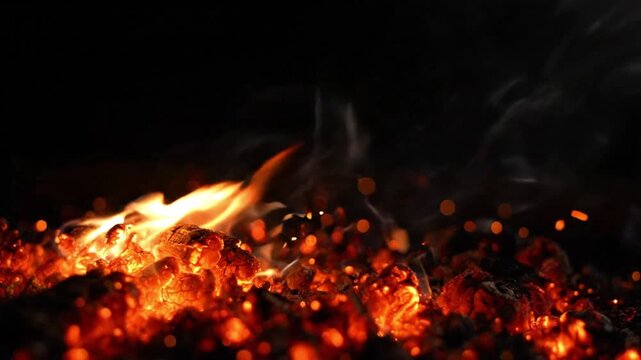 Glowing Embers and Flames Visible in Dark Background