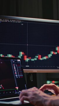 Unrecognizable man stock trader in home office. Male analyzes terminal, trades stocks on crypto market. Quotes from Bitcoin Ethereum. Candlestick or trading charts, price action on the laptop screen
