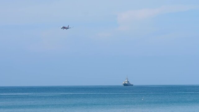 Jet airplane landing at Phuket International Airport. Airplane flying over Mai Khao beach. Travel concept.