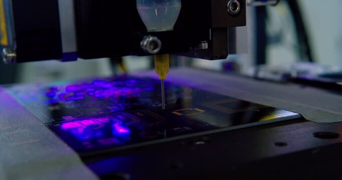 Close-up video of a modern high-tech automated machine precisely assembling an electronic printed circuit board.