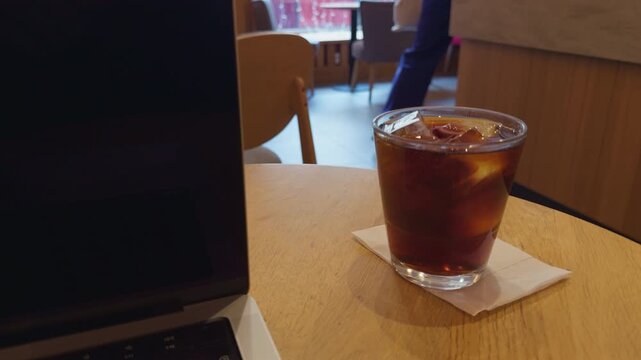 Coffee by street. Casual scene of coffee and city life. Streetside coffee setting captured from low angle perspective. Candid shot showcasing iced coffee on corner table with urban street scenery