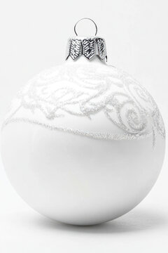 A decorative white Christmas tree ornament with a silver finial on top