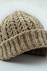 Fototapeta premium A single knitted hat sits on a clean white surface