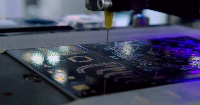Modern high-tech production. An automated high-precision machine assembles an electronic printed circuit board. A close-up shot of the process.