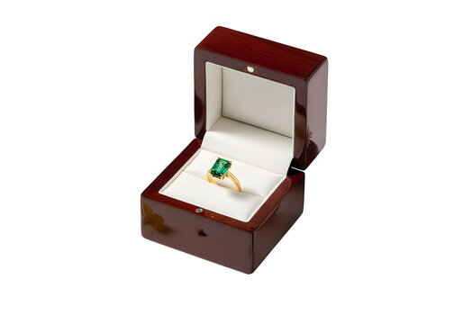 Elegant red velvet jewelry box with an emerald ring inside isolated on white background