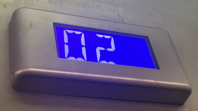 Digital floor indicator display showing blue numbers  on elevator cabin, vertical transport technology. elevator display, floor numbers, digital screen, lift interface, modern building.
