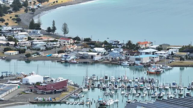 A wide view of a Ahuriri marina filled with sailboats and motorboats docked in the water. The boats are neatly arranged in rows. Napier, Hawkes Bay, New Zealand 