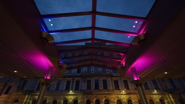 Moody neon canopy above arcade, latenight cinematic scene with dramatic shadows, purple highlights and historic windows, perfect for film location scouting, nightlife editorials and atmospheric k