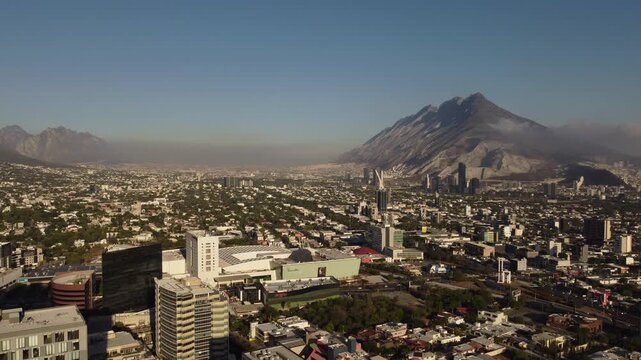 Aerial drone view of Monterrey city urban sprawl with Cerro de la Silla mountain and smog layer Nuevo Leon Mexico