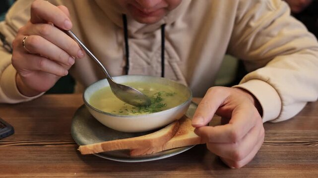 Close-up of a man eating noodle soup in a restaurant. Slow motion video.