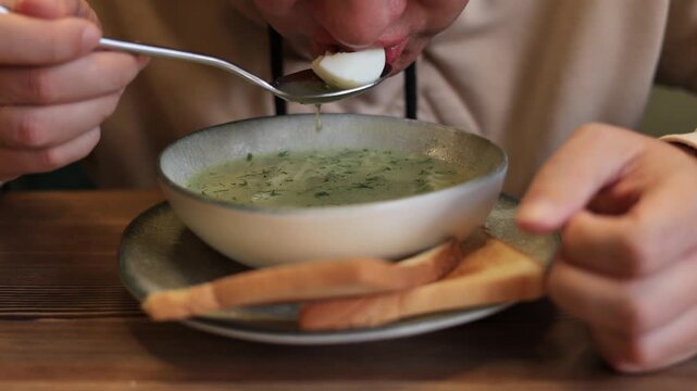 Close-up of a man eating noodle soup in a restaurant. Slow motion video.