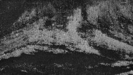 Abstract black-and-white texture of rough, layered surfaces. Dark and light tones create a gritty,...