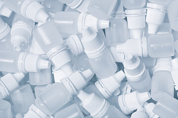 Obraz premium White plastic medical bottles vials for medicinal nose or eye drops as a solid white textured background, medical health concept