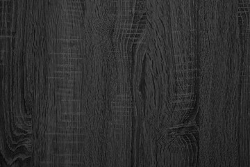 Obraz premium Close-up of dark, textured wood grain pattern. Rugged surface shows natural vertical lines and swirls. Ideal for backgrounds, design projects