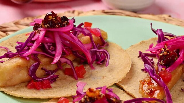 Close-up of a crispy battered fish taco on a corn tortilla with salsa macha and colorful salad