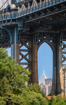 New york, usa august 15,2024. Manhattan bridge framing the empire state building and manhattan skyline from dumbo, brooklyn  iconic nyc urban architecture view