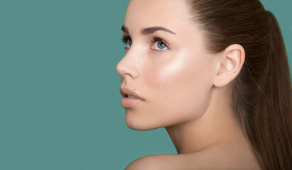 Naklejka premium Beautiful young women face with perfect fresh skin and makeup. Portrait of model with make-up, formed eyebrows and long eyelashes. Beauty and Spa, skincare and wellness. Selective focus.