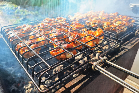 Grilled chicken pieces on barbecue