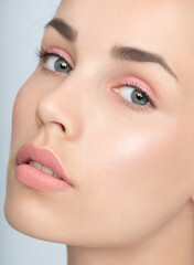 Obraz premium Beautiful young women face with perfect fresh skin and makeup. Portrait of model with make-up, formed eyebrows and long eyelashes. Beauty and Spa, skincare and wellness. Selective focus.