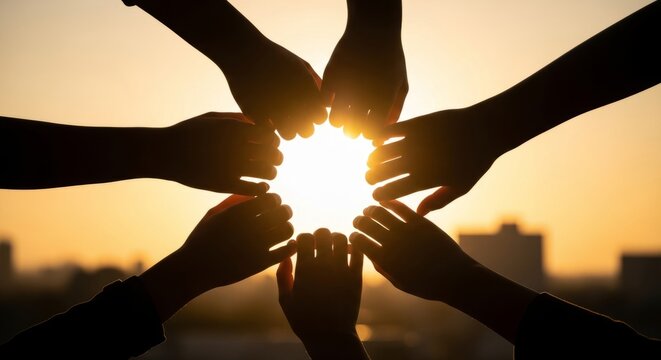 Hands forming a circle against sunset sky representing unity