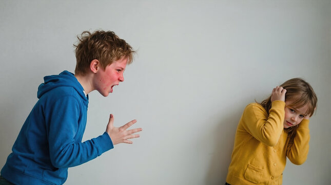 Angry boy yelling at young girl covering her ears. Concept of verbal abuse and childhood conflict. Distressed child reacting to shouting