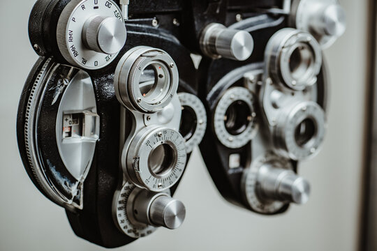 Side view of professional phoropter for eye examination. Angled view of a manual refractor showing the complex mechanical layers of the ophthalmic testing device.