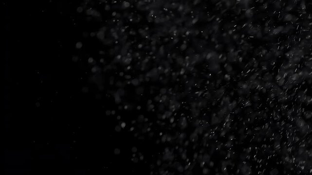 Gust of Wind Snow. Small white particles flow in the air on a black background to simulate snow, blizzard, or a microcosm of the Christmas magic