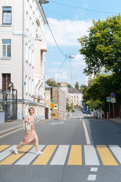Young modern woman crossing street in Moscow