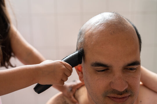 Girl cutting her father's hair. 