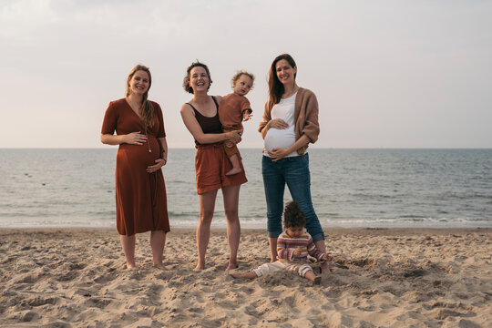 Group of 3 moms with their children at the beach