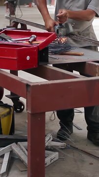 Worker Using Angle Grinder on Metal Bar in Industrial Workshop - Vertical Video 4K