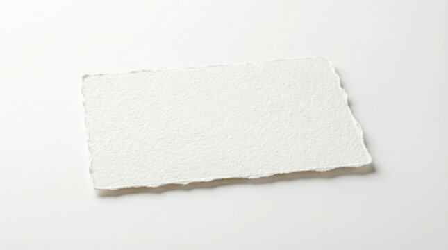Blank white handmade paper sheet with deckle edge on light background.