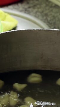 Vertical Close Up of Gnocchi Being Scooped from Boiling Water - 4K