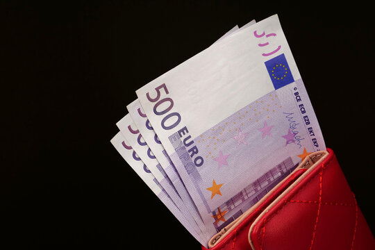 Four freshly printed 500 Euro banknotes stacked in a red wallet, illustrating a total of 2000 Euros, ideal for savings and investment