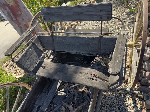 A weathered wooden seat on an old buckboard wagon in San Marcos, California.