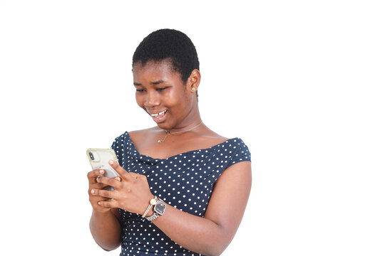 Woman in a navy blue polka dot dress focused on her smartphone