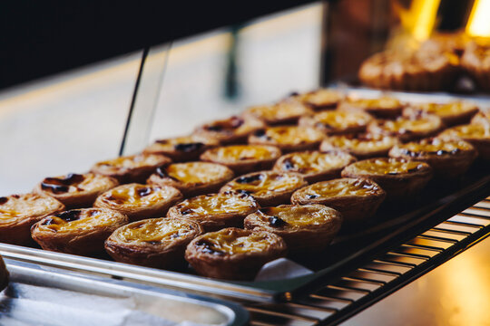 Pasteis and Pastel de nata, traditional Portuguese egg custard tart pasty cakes, dessert Pasteis de nata with different pastry in the cafe, bakery display window, Pastel de belem, Lisbon, Portugal